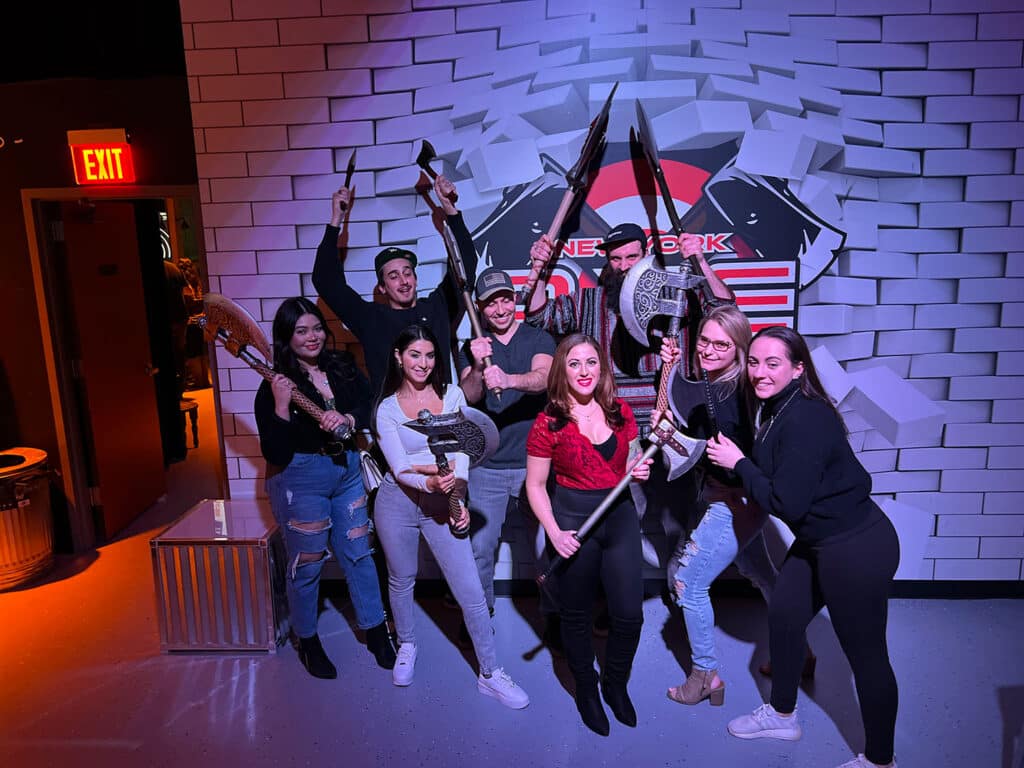 A group of people holding axes at an axe throwing range