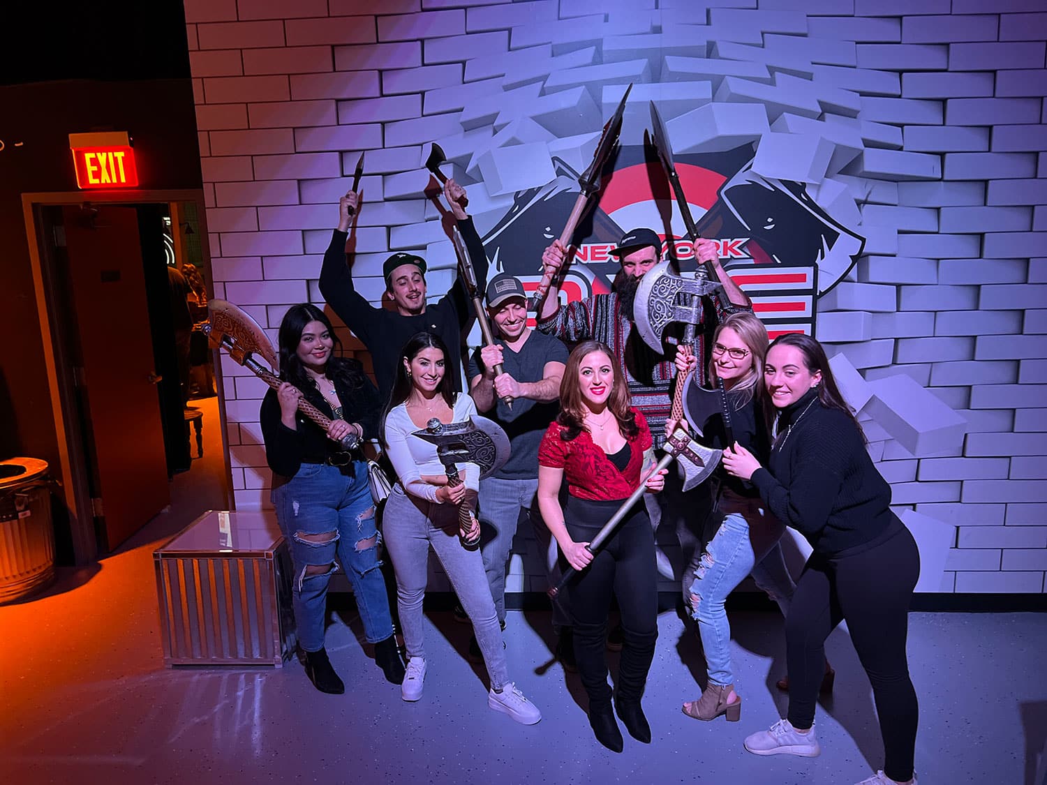 A group of people holding axes at an axe throwing range