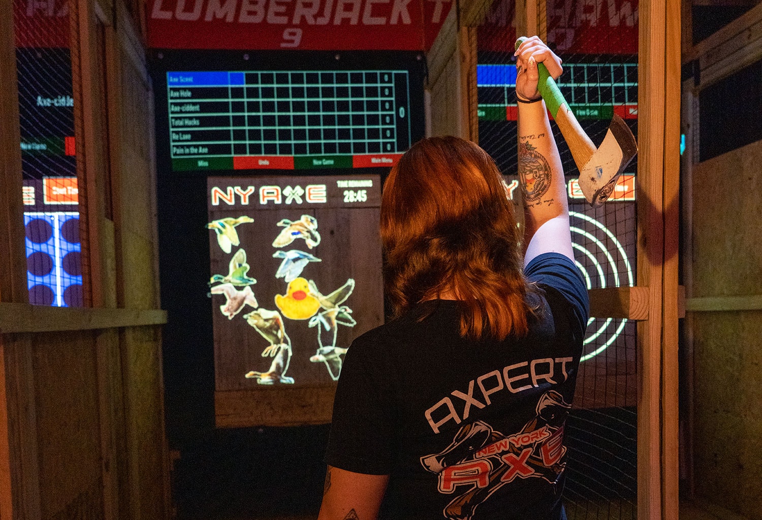 Axe throwing coach throwing an axe at a target